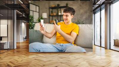 Adult young man have contactleess payment on mobile phone at home Wall mural