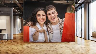 close up of young adult costumer couple with shopping bags Wall mural