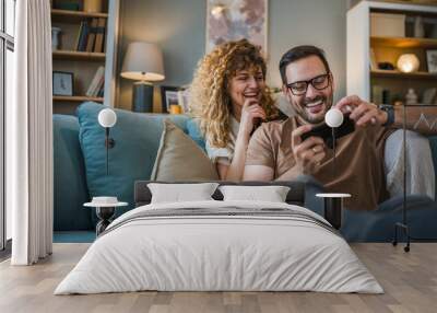 couple man and woman husband wife play smart phone video games at home Wall mural