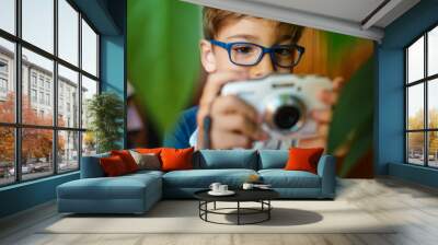 Front view close up on caucasian boy four years old using digital camera taking pictures modern technology growing up and learning developing skills leisure activity Wall mural