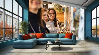 Group of women caucasian female friends standing by the aquarium at home watching fishes side view copy space friendship and leisure concept Wall mural