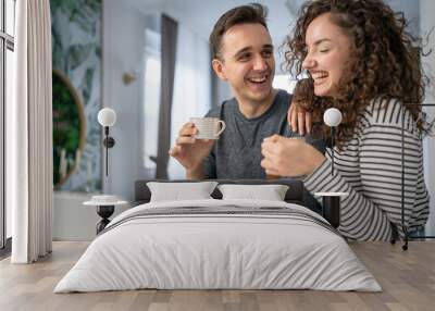 happy couple using laptop computer with cup of coffee morning routine Wall mural