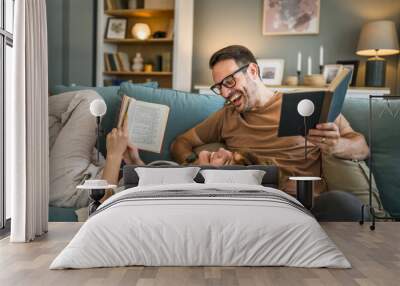 man and woman caucasian adult couple read books at home on sofa bed Wall mural