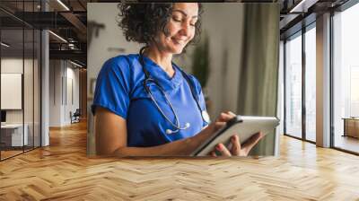 mature woman doctor stand and use digital tablet at home Wall mural