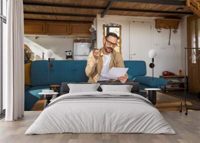 one adult man sit at home make a call while hold paper documents Wall mural