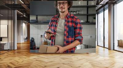 one man checking box of received package or product at home Wall mural