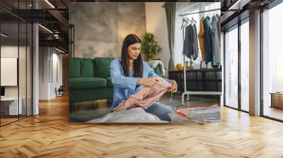 One woman caucasian adult at home choose clothes for charity donation Wall mural