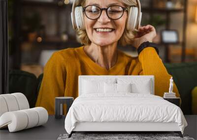 One woman with headphones at home listen music online happy smile Wall mural