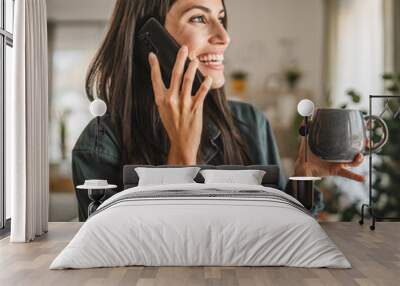 Portrait of adult young woman stand hold cup and talk on mobile phone Wall mural