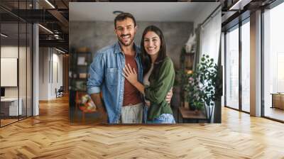 Portrait of beautiful couple stand, smile and hug at home Wall mural