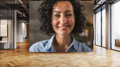 Portrait of happy adult mature woman with curly hair stand at home Wall mural