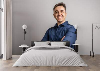 Portrait of one adult caucasian man 25 years old looking to the camera in front of white wall background smiling wearing casual blue shirt copy space Wall mural