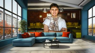 Portrait of young caucasian man stand and smile indoor Wall mural