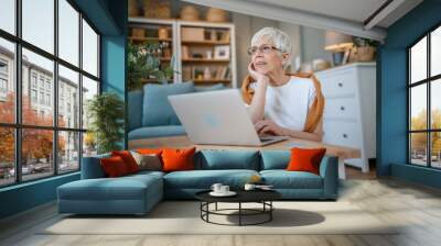 Senior caucasian woman use laptop computer at home for work Wall mural