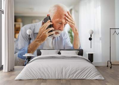 Senior man sit at home have a phone call while receive bad report Wall mural