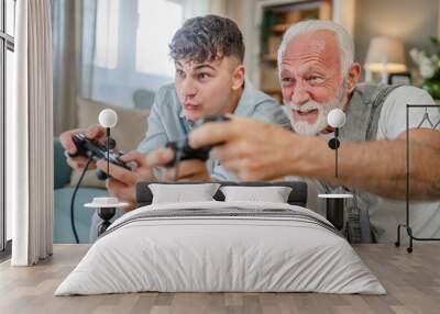 teenager male and his grandfather senior man play console video game Wall mural