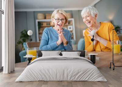 two senior women friends or sisters play leisure board game at home Wall mural