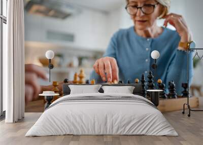 two women mature senior females sisters play chess board game at home Wall mural