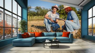 woman and man farmers in the field check quality of the soil Wall mural