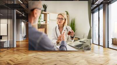 Woman doctor hold medicament and medical document and show patient Wall mural