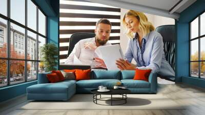 Young caucasian adult man and woman at office looking digital tablet Wall mural