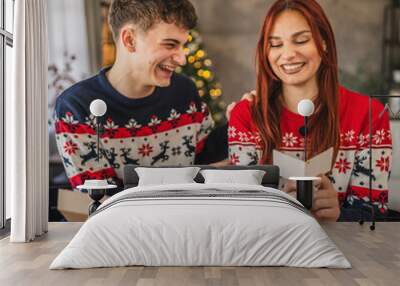 Young couple read greeting card during video call on digital tablet Wall mural