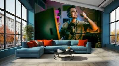 Young man male gamer playing computer game streaming video winning Wall mural