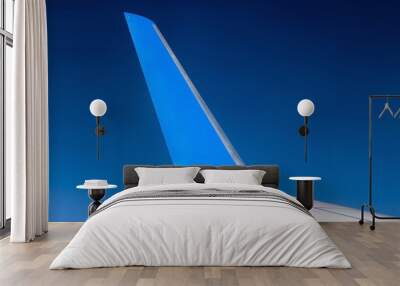 The blue winglet on a wing of plane when a flight in a blue sky. Part of jet wing, close view. Wall mural