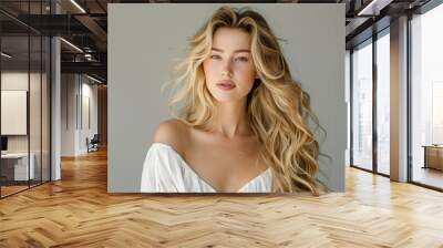 Indoor portrait of curly hairstyle woman. Blonde fashion model with wavy long hairdo portrait. Volume, coiffure, cosmetic, hair care and hair treatment concept Wall mural