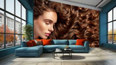 Top view of female model with fresh clean skin, natural makeup and long wavy hairstyle posing on studio background. Coiffure, cosmetic and hair care concept Wall mural