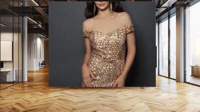 Beautiful fashion model woman in gold evening gown on black background Wall mural