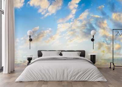 Blue sky clouds background. Beautiful landscape with clouds and orange sun on sky Wall mural