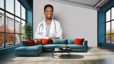 Confident happy doctor woman medical worker in lab coat on white background Wall mural