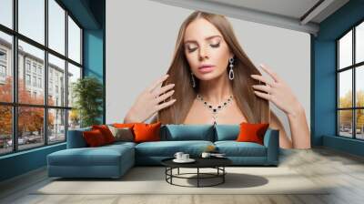 Elegant jewellery model woman wearing stylish gold earring and necklace with blue crystal sapphire and diamond on white studio wall background Wall mural