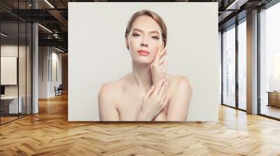 Elegant perfect young woman touching her hand her face. Beautiful model with natural clear skin portrait Wall mural