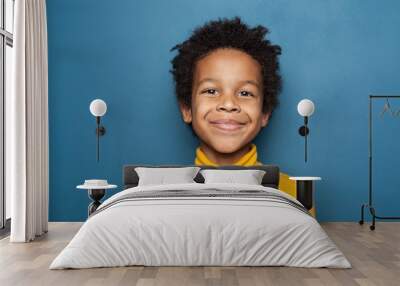 Happy child portrait. Little african american kid boy on blue background Wall mural