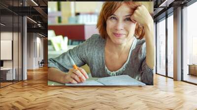 Happy mature woman with notebook portrait Wall mural