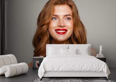 Happy redhead woman smiling. Excited red head girl with curly hairstyle. Ginger hair, cute smile, red lips makeup. Natural authentic beauty Wall mural