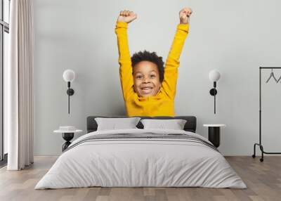 Little black child win-win! Kid boy having fun on white background Wall mural