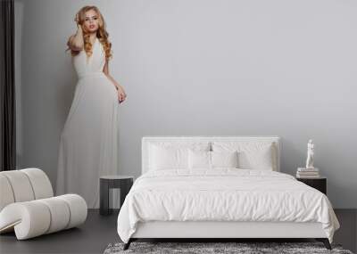 Perfect woman in white dress posing against white background Wall mural