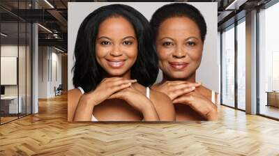 Portrait of healthy brunette women. Mature mother and young daughter smiling on white background Wall mural