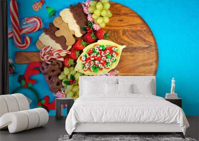 Happy Holidays Christmas bright colorful large dessert grazing platter charcuterie board with gingerbread, cookies, candy and fruit on bright pop color background, with negative copy space. Wall mural