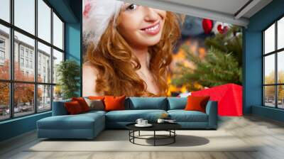 Christmas woman near a Christmas tree holding big gift box while Wall mural