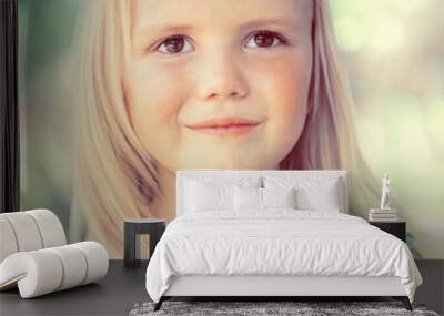 Cute little girl on the meadow in summer day Wall mural