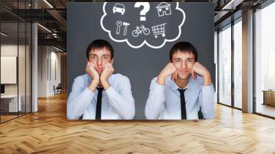 Image of two young similar men thinking of their plans sitting t Wall mural