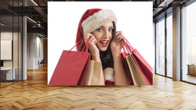 Woman wearing Santa Claus hat with shopping bags Wall mural