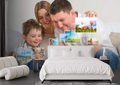 young happy family watching their photo and video files using mo Wall mural