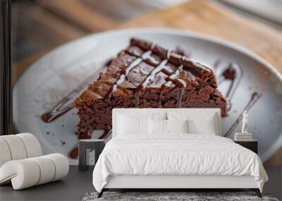 a piece of brownie cake with melted chocolate on a white plate Wall mural