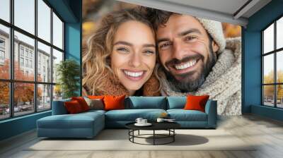 A close-up of a happy couple cuddling close, showcasing their warm smiles and cozy attire against the backdrop of a beautiful autumn day, full of love. Wall mural