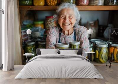 An elderly woman, full of cheer, displays jars of pickles in a rustic pantry, capturing the charm and satisfaction of homemade preservation and artistry. Wall mural